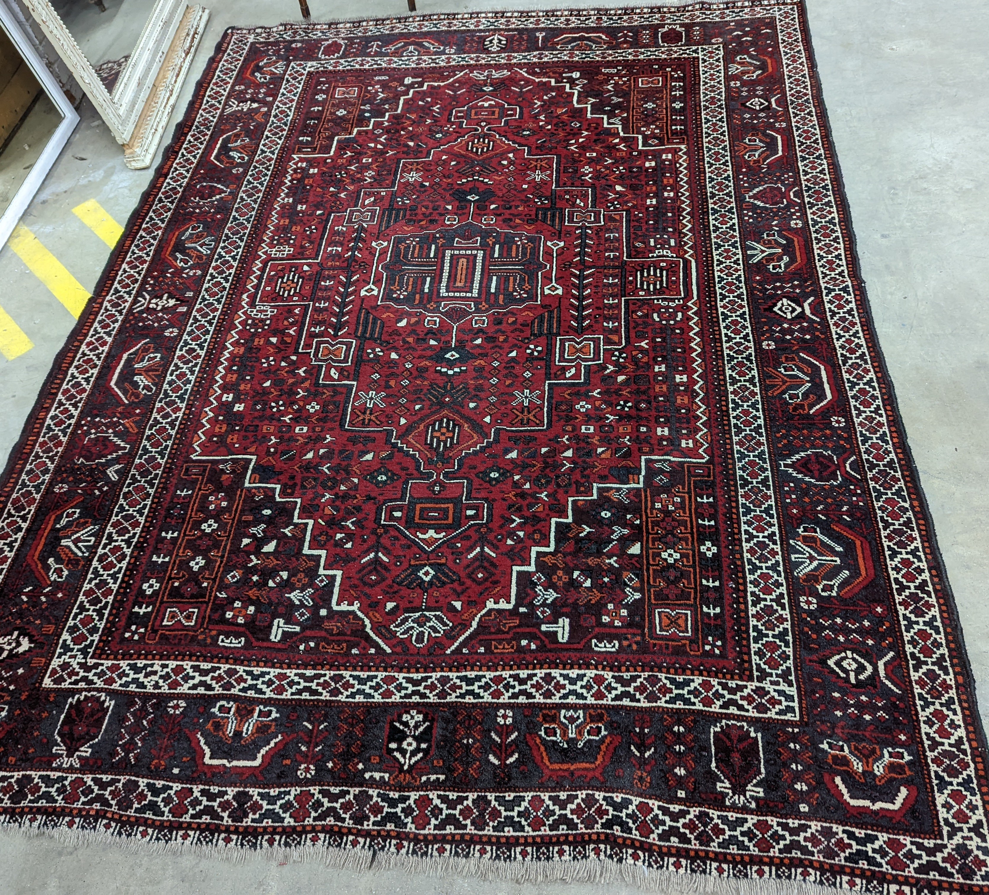 A Caucasian design burgundy ground carpet, 280 x 210cm